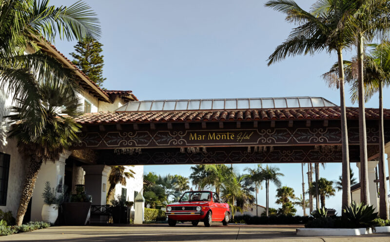Cute red car pulling into hotel front valet