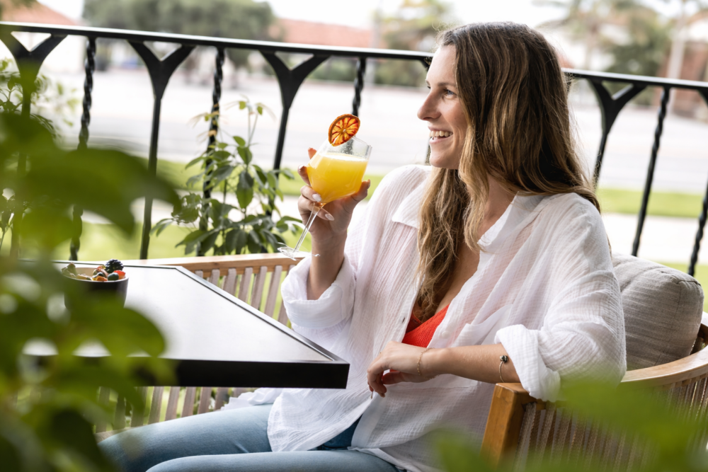 Woman sitting on patio having orange juice